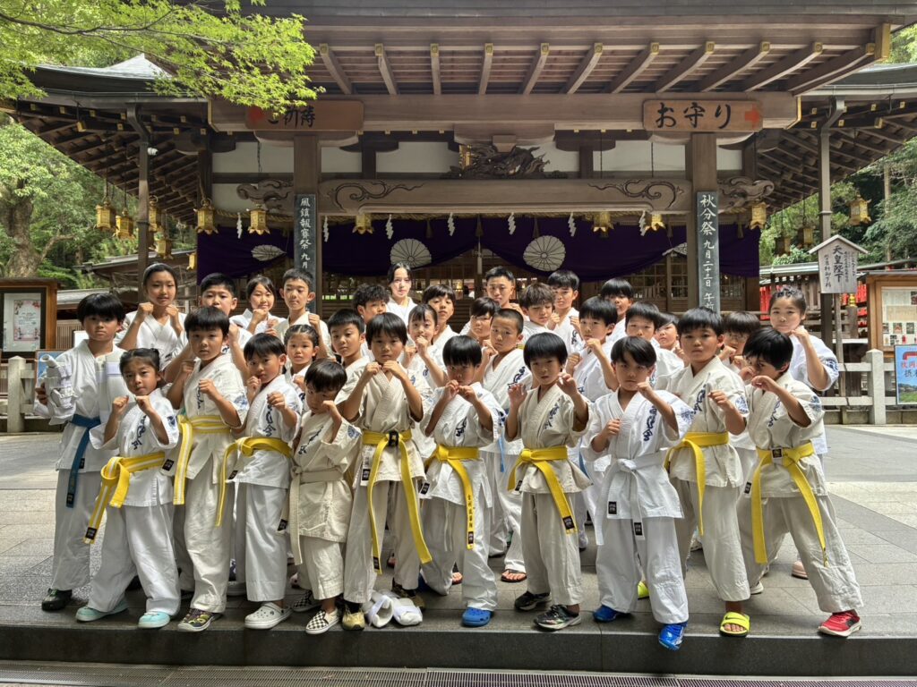 神社の前で集まってポーズをとる福井道場の道場生たち